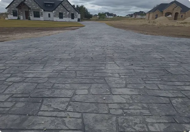 Concrete driveway with caution tape, showcasing a newly installed surface in front of a residential home.