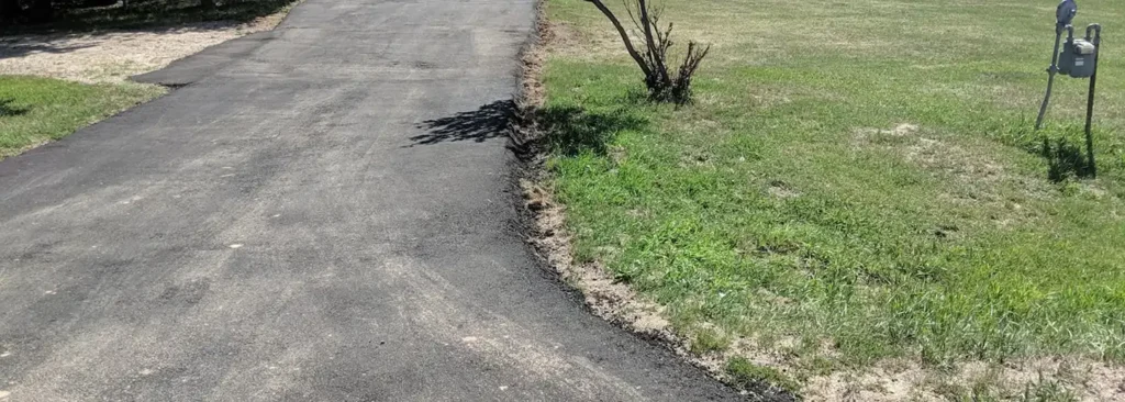 Concrete driveway with caution tape, showcasing a newly installed surface in front of a residential home.