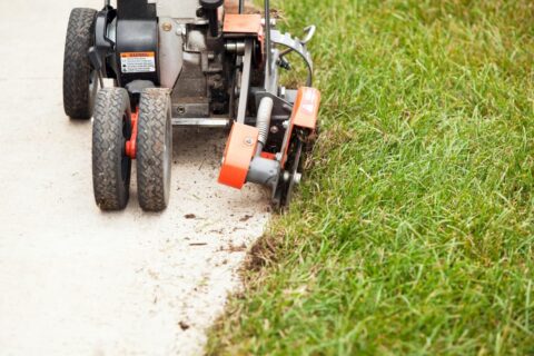 Concrete driveway with caution tape, showcasing a newly installed surface in front of a residential home.